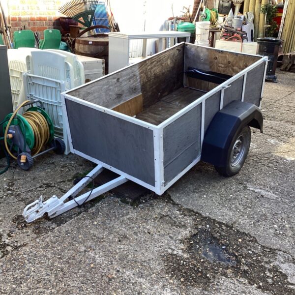 Side view of a homemade garden trailer with metal panels.