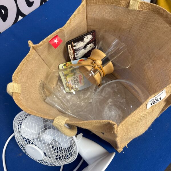 House clearance lot with vintage fan, pouring jug, and branded coasters.