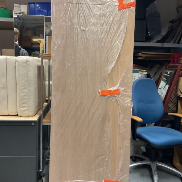 Howdens Holdenby oak door wrapped in protective plastic film with orange tape