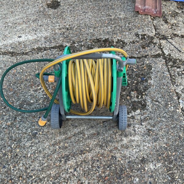 Hozelock hose cart with yellow garden hose for watering.