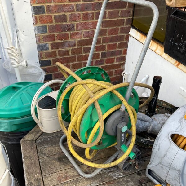 Used Hozelock hose reel with green garden hose attached.
