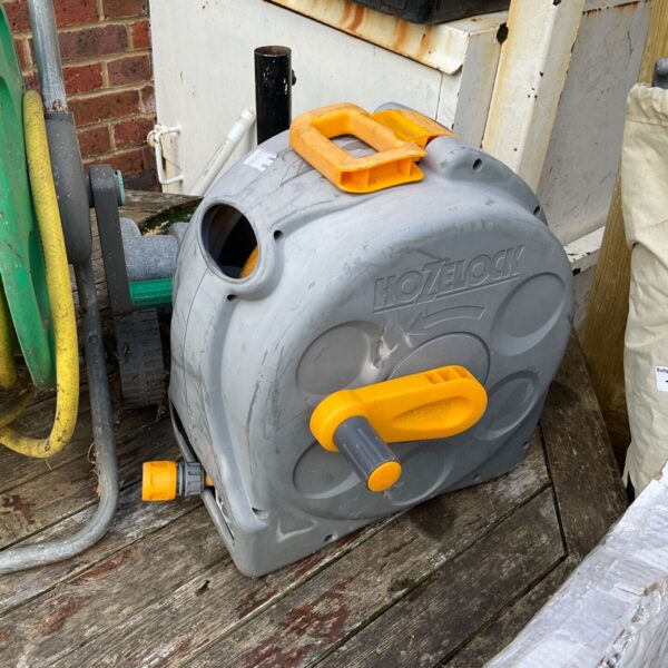 Used Hozelock hose reel in a garden setting.