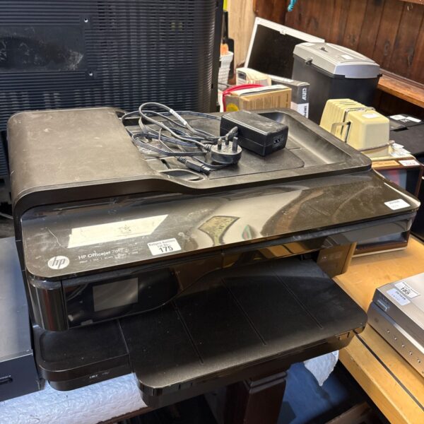 Black HP Officejet 7612 all-in-one printer with power supply and cables on top