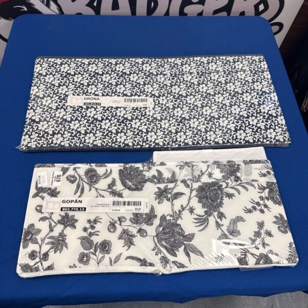 Two sealed IKEA fabric storage cubes, one navy floral and one black and white botanical
