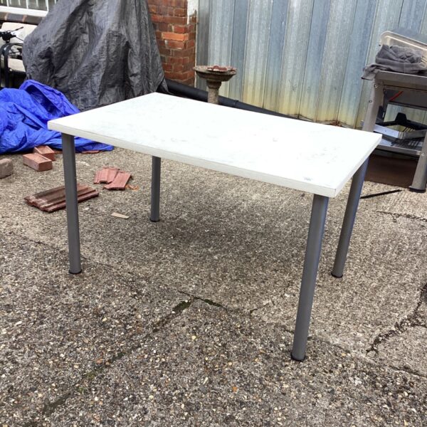 White Ikea table in a garden setting, showing signs of wear.