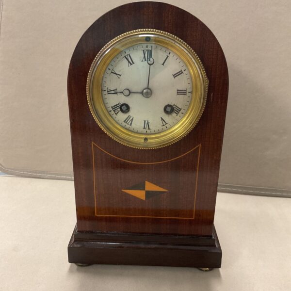 Antique inlaid mantle clock with Roman numeral dial.