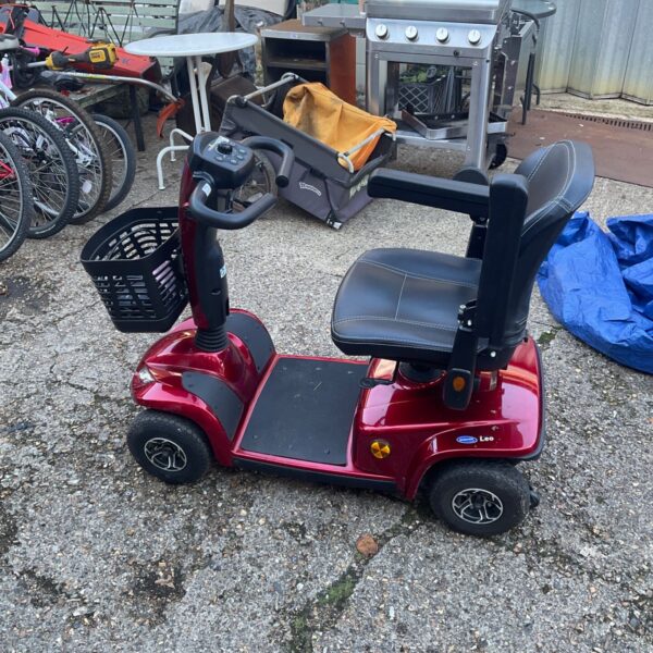 Red Invacare Leo mobility scooter with black seat and front basket