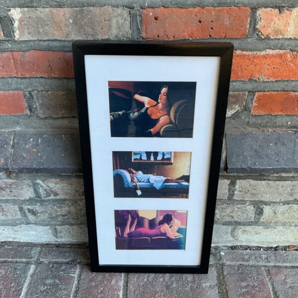 Framed Jack Vettriano prints of elegant ladies on a wall.