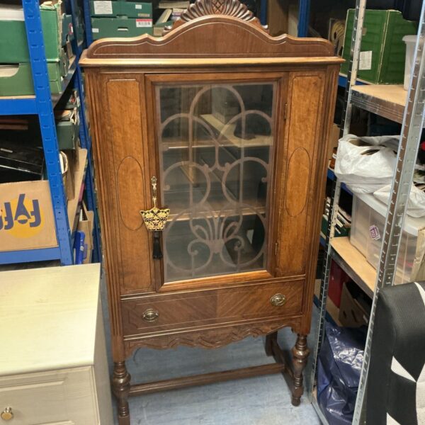 Vintage Jacobean china cabinet with glazed door for displaying collectibles.