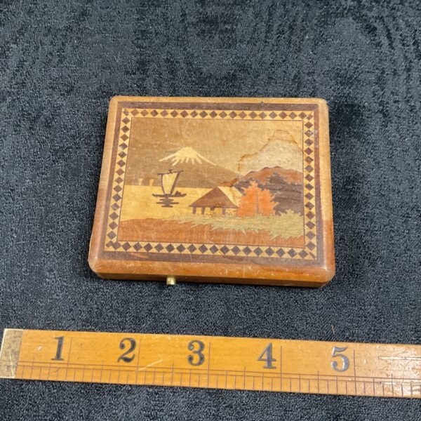 Antique Japanese inlaid puzzle box with Mount Fuji scene.