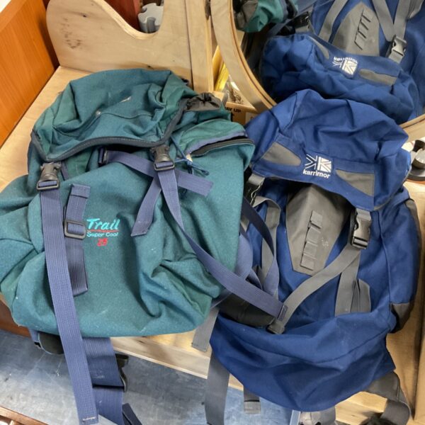 Karrimor and Trail Super Cool 25 rucksacks in green and blue, grouped together