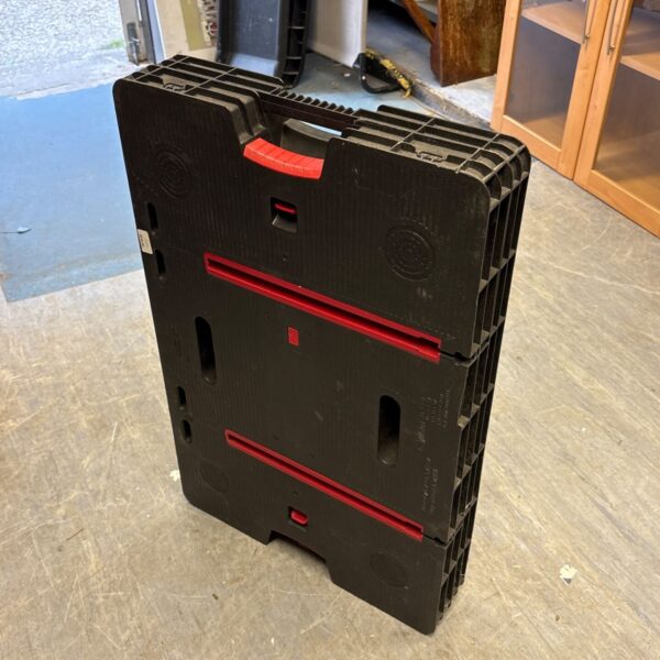Black Keter folding work table, side view, showing folded design.