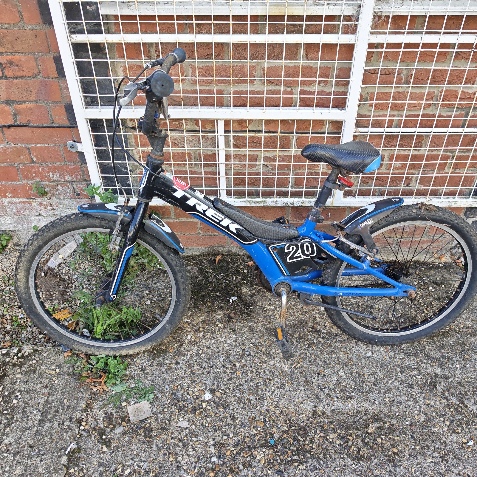 Blue Trek kids bicycle with front suspension and knobby tires.