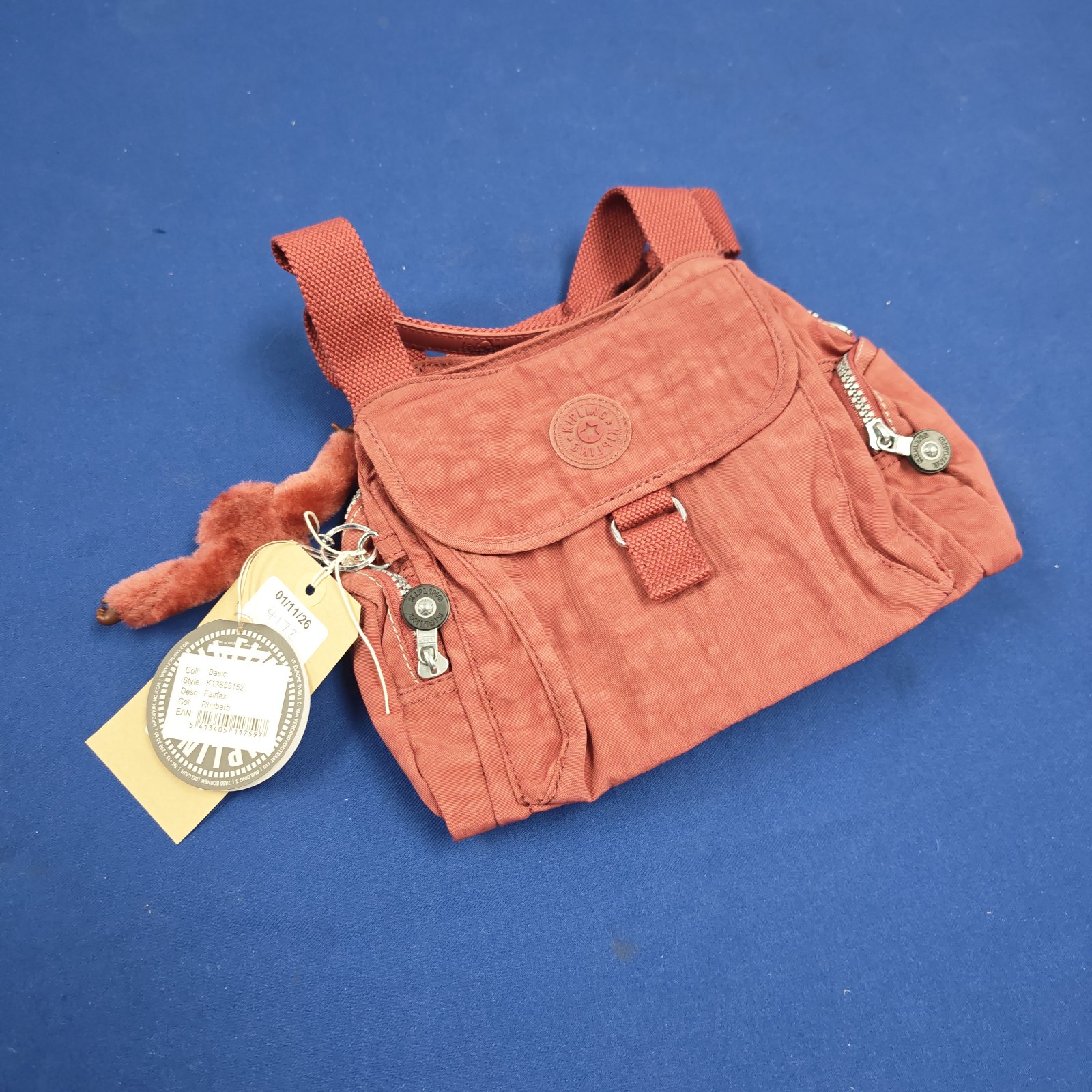 Rhubarb coloured Kipling Fairfax handbag with woven straps and tag