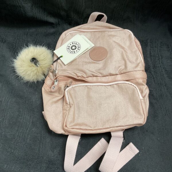 Glam pink Kipling backpack with front pocket and cream charm