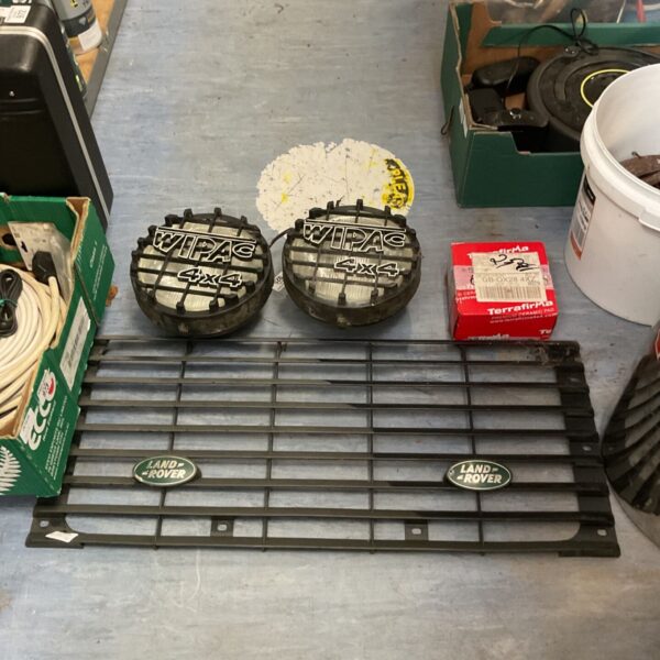 Pair of Wipac 4x4 driving lamps and Land Rover front grille on floor