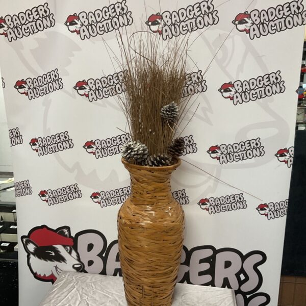 Large woven bamboo vase holding dried grasses and pine cones