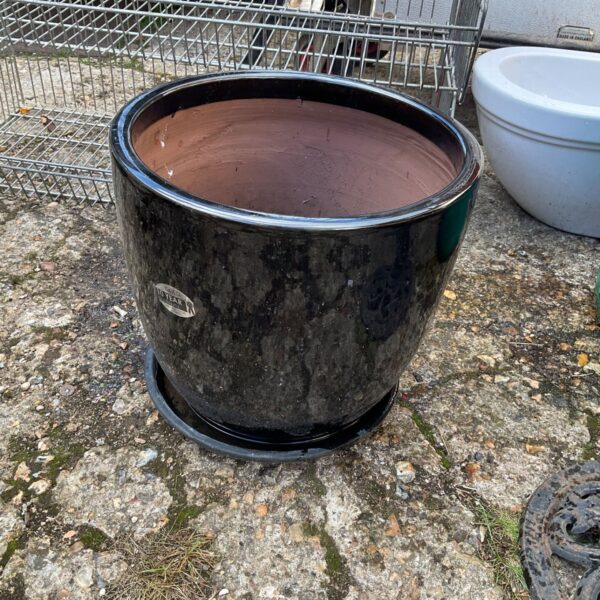 Large black garden planter for outdoor plants and garden decor.