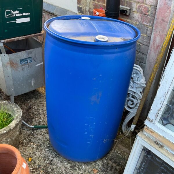 Large blue water butt for rainwater harvesting in a garden setting.