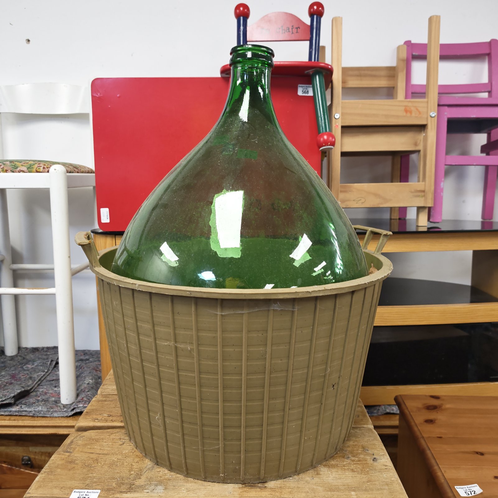 Large green glass carboy in a tan moulded carrier with handles