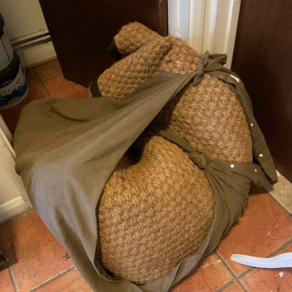Large hessian bell tent floor rug rolled and bound in olive fabric