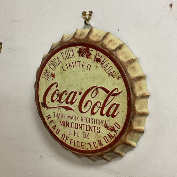 Large metal Coca-Cola bottle cap wall sign with fluted rim and red script logo