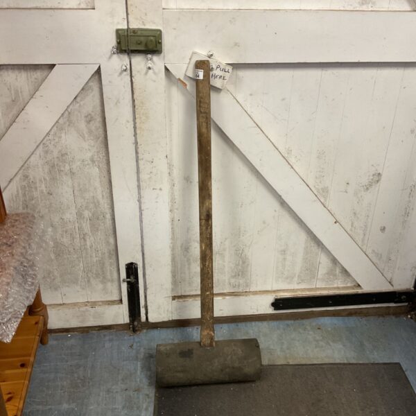 Large black rubber mallet with a wooden handle, vintage tool.