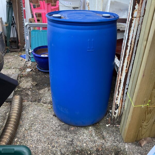 Large blue water butt in a garden setting.