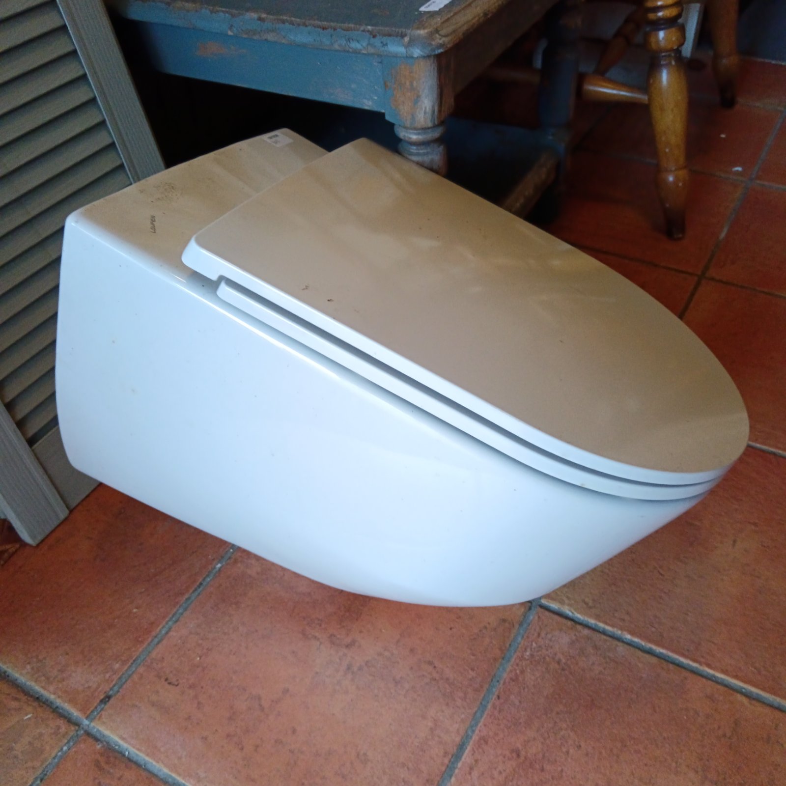 Laufen wall hung toilet with soft close seat in a bathroom setting.
