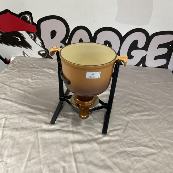 Le Creuset fondue set with orange enamelled cast iron pot on black stand