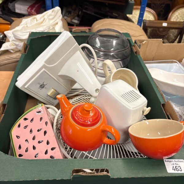 Orange Le Creuset teapot with mixed kitchen items in a box.