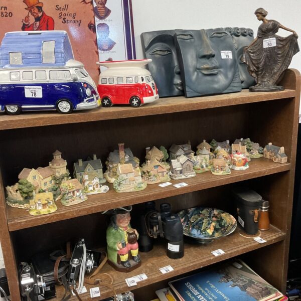 Collection of Lilliput Lane miniature cottages displayed on a wooden shelf