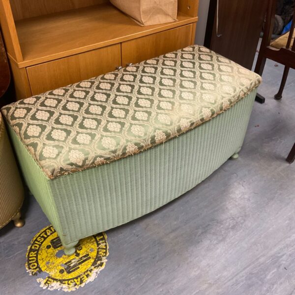 Vintage green Lloyd Loom blanket box with a padded top.