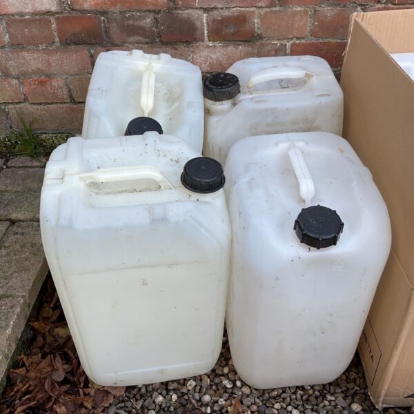 Lot of four large white plastic water containers with black screw caps