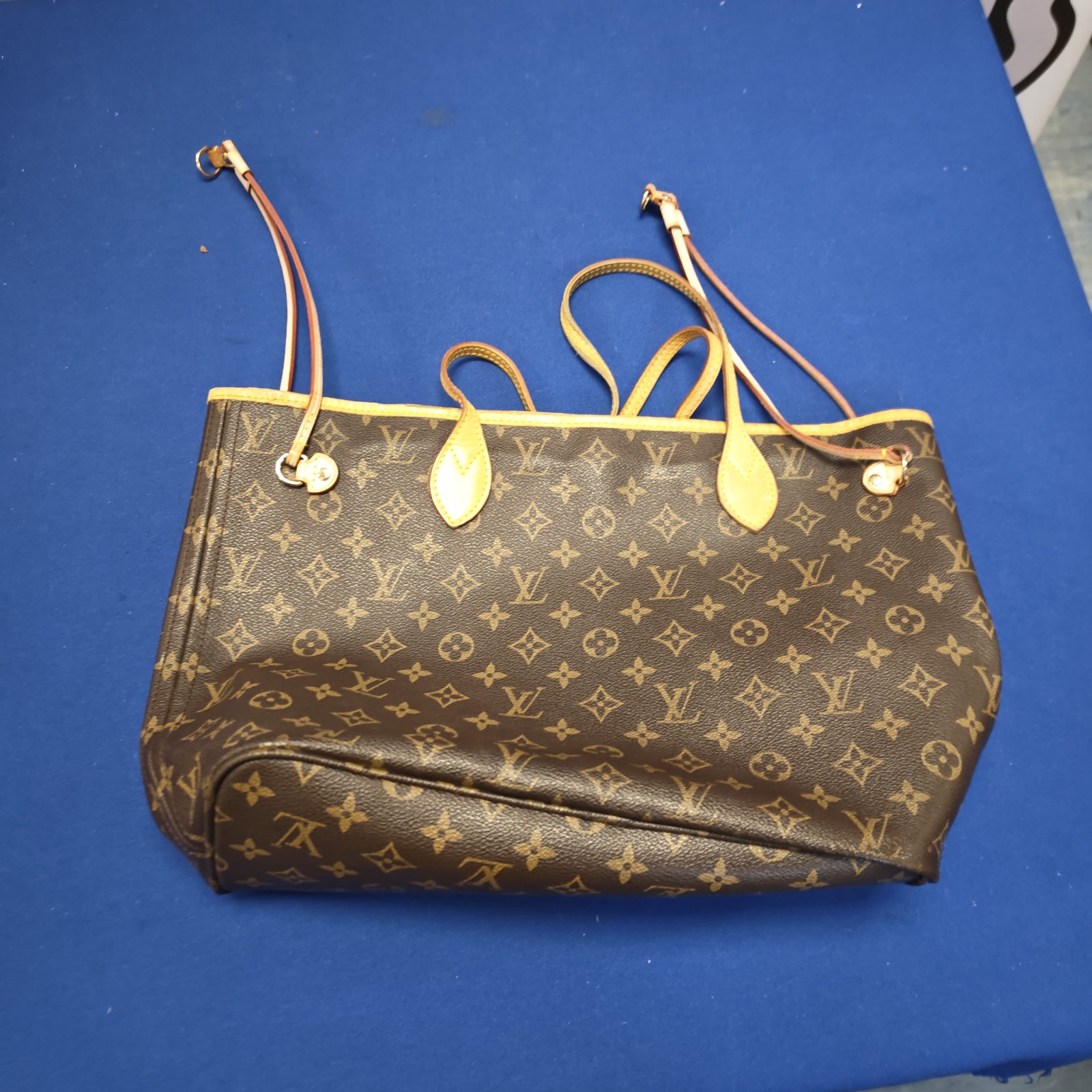 Louis Vuitton style handbag with monogram canvas and leather handles.