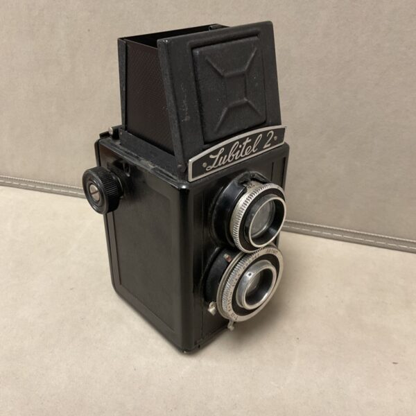 Black Lubitel 2 twin lens box camera viewed from the side with pop-up hood raised