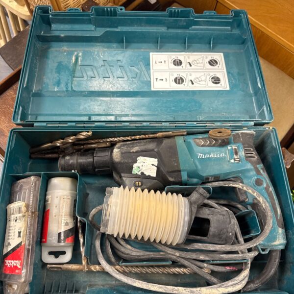Open Makita HR2610T drill case with drill inside.