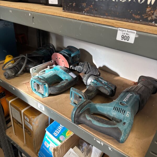 Assorted Makita power tools on a shelf, including a sander and router.