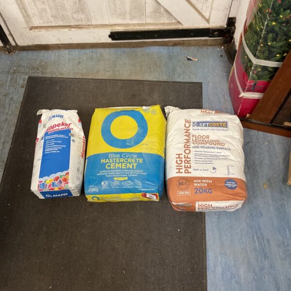 Three bags of Mapei cement for construction and repair projects.
