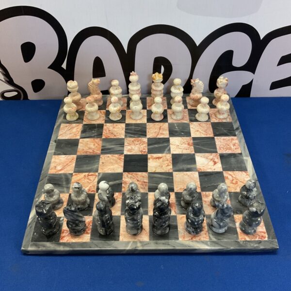 Vintage marble chess set with black and pink board and pieces.