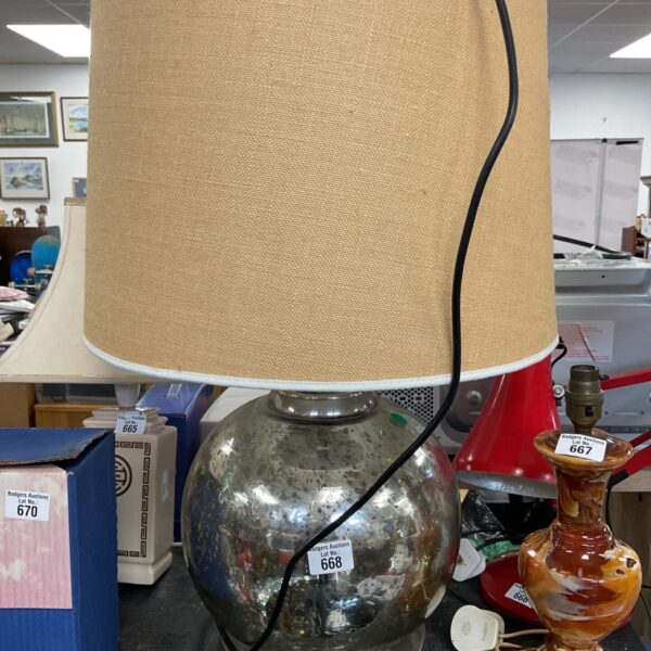 Distressed mercury glass table lamp with neutral shade.