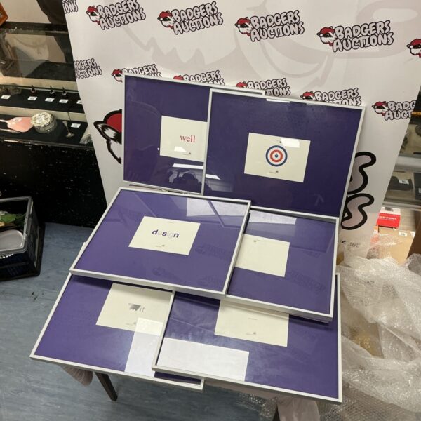 Six metal edged picture frames with purple backing and framed word prints