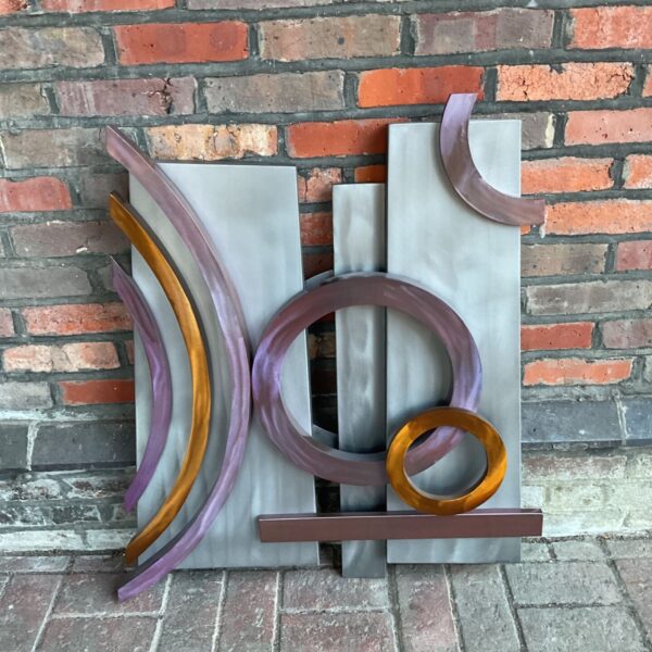 Contemporary metal wall sculpture with geometric design.