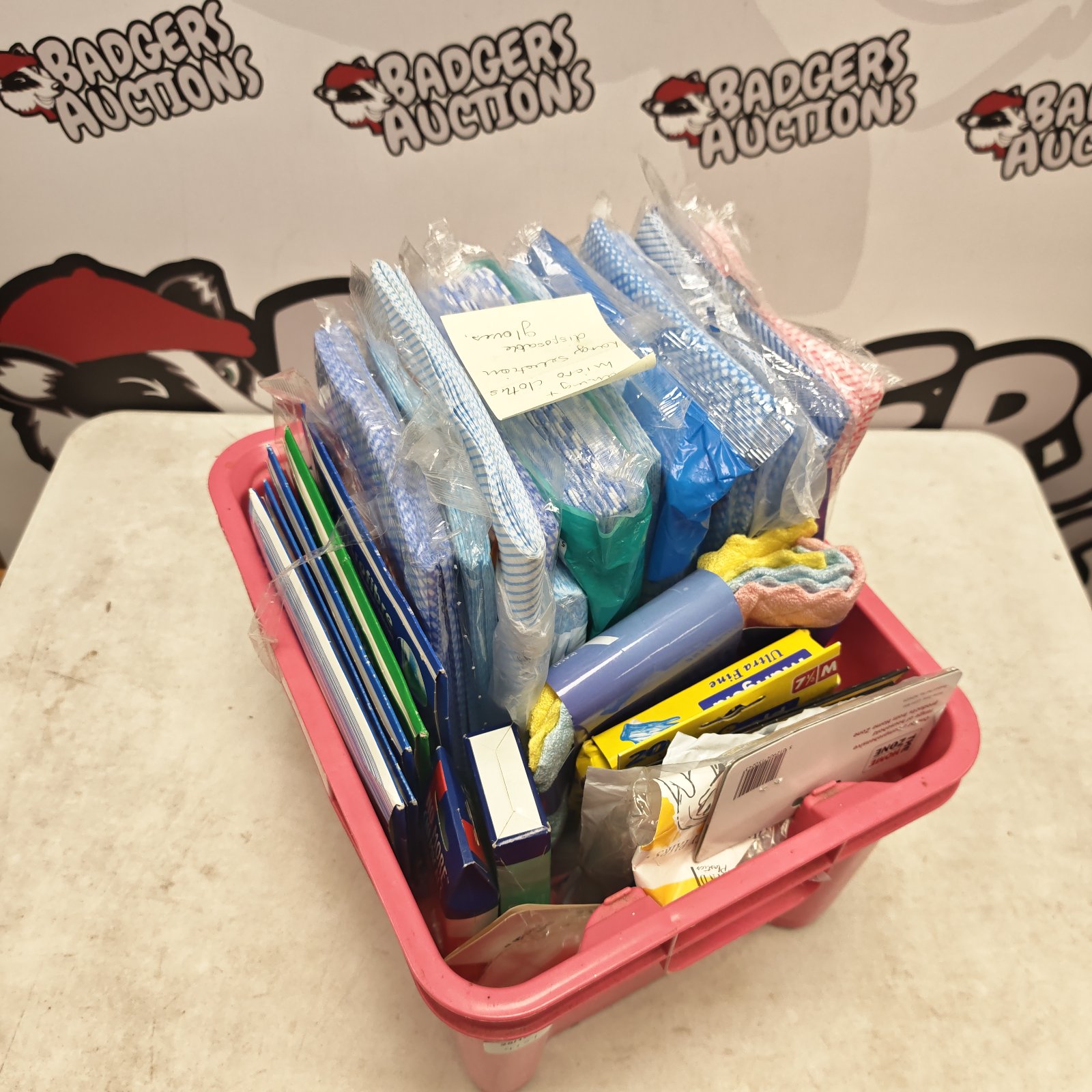 Box of microfibre cloths and disposable gloves in pink storage crate