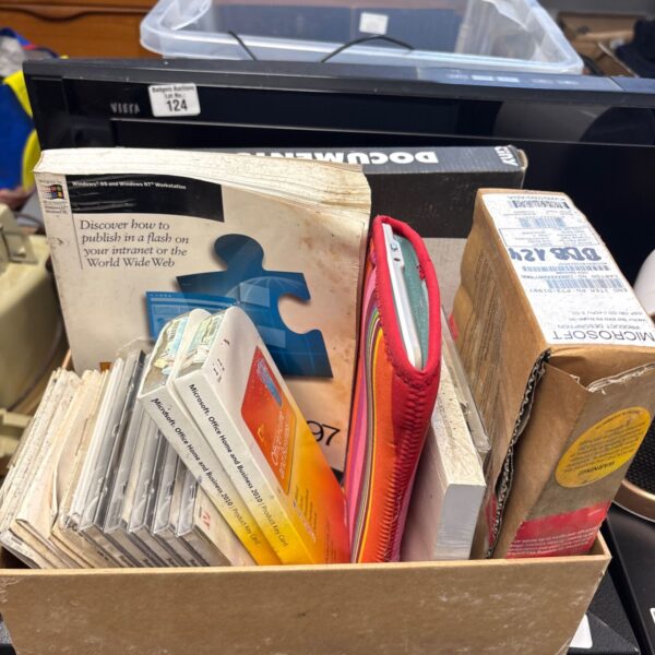 Box of Microsoft computing software with Office 2010 packs and Windows 95 book