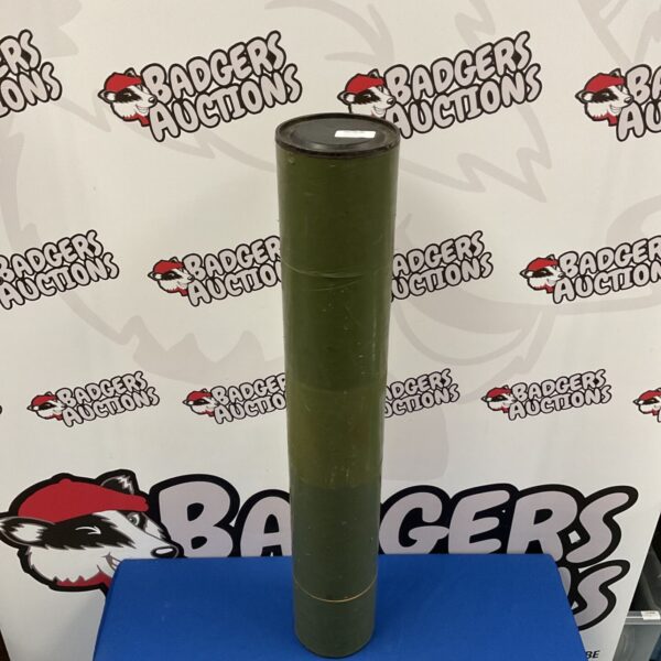 Olive drab military mortar shell tube with auction backdrop.