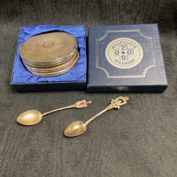 Hallmarked silver Millennium coaster set with spoons, collectible silverware.