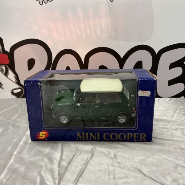 Green diecast Mini Cooper model car with white roof in blue display box