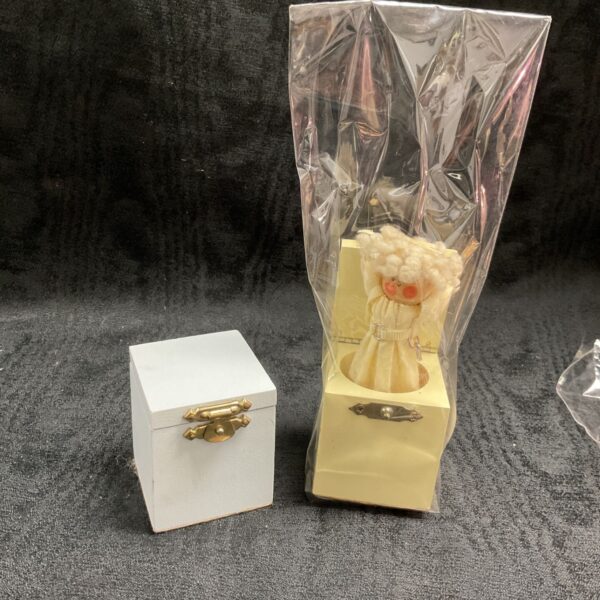 White miniature Jack in the Box toy with a hinged lid.