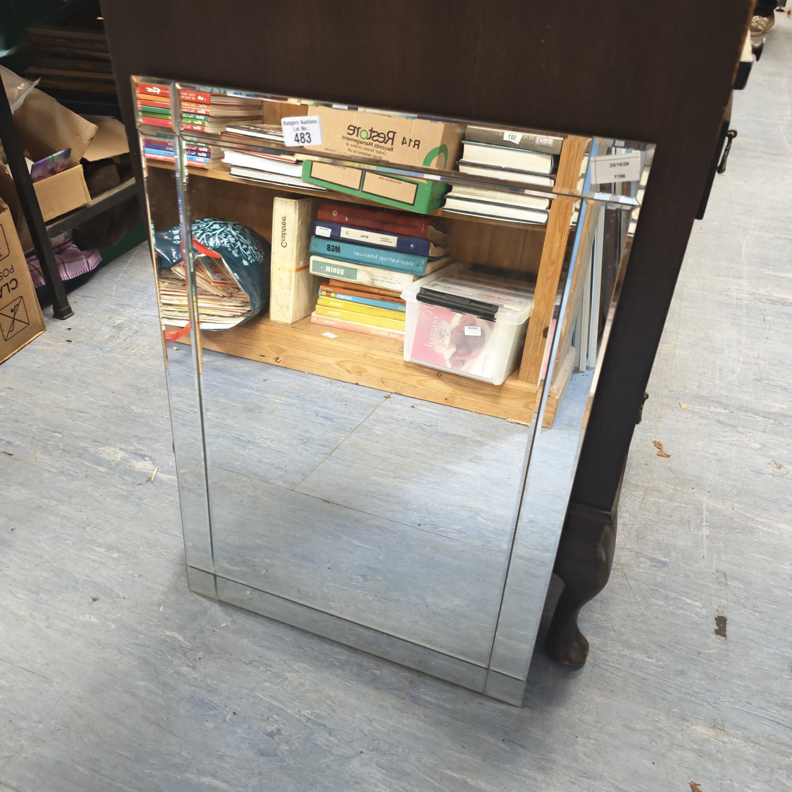 Rectangular mirror with mirrored edge border on a grey floor